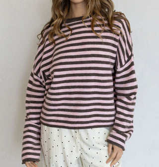 Model wears a pink and brown striped sweater with white and black micro-polka dot pants