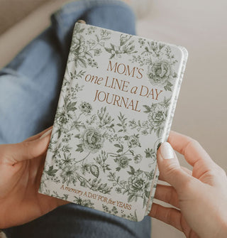 Model's hands hold a green Delft Mom's One Line a Day Journal