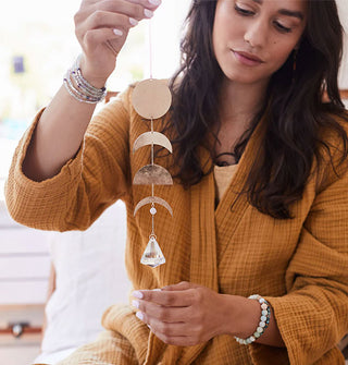 Model holds a brass and crystal suncatcher from its chain
