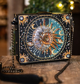 Black rectangular handbag with chain strap features a completely beaded design of a sun and crescent moon surrounded by other celestial symbols on its face