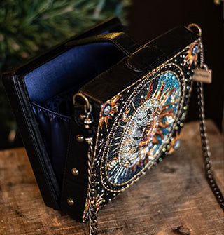 Opened beaded sun and moon purse with chain strap reveals a dark blue interior with ruched sides and three gold studs along the outer edge