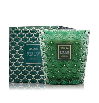 Green embossed glass Noble Fir Garland Voluspa candle vessel alongside its matching gift box