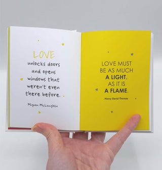 Model's hand holds Olive You open to a page spread featuring quotes by Mignon McLaughlin and Henry David Thoreau