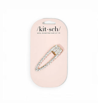 Rhinestone-accented gold hair clip with triangular open shape is attached to a light pink Kitsch product card