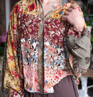 Model wears a button-down shirt with patchworked floral prints and billowy sleeves