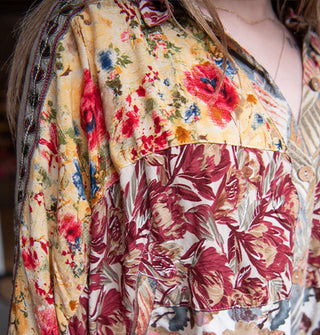 Closeup of a button-down shirt with patchworked floral prints and sleeve embroidery