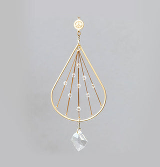 Gold-toned teardrop-shaped ornament with peace sign charm at top, crystal dangle charm at bottom, and small crystals staggered throughout its middle