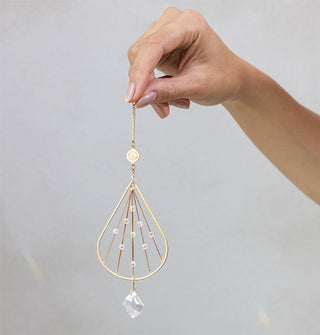 Model's hand holds a teardrop crystal suncatcher ornament