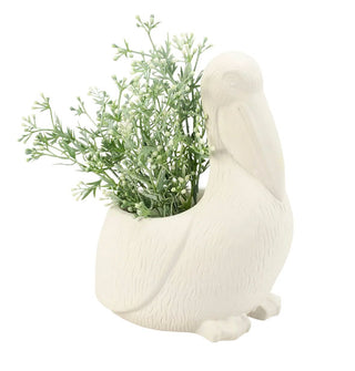Matte white sitting pelican planter pot with greens placed in its opening
