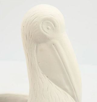 Closeup of the facial details on a matte white pelican planter pot