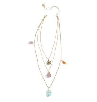 Brass chain necklace with three strands of varying lengths each featuring one central crystal and the longest featuring two additional crystals placed at the sides