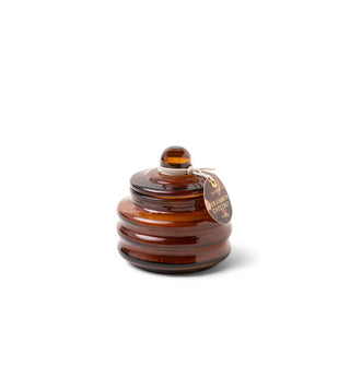 Small brown ribbed glass candle jar with round tag hanging from its knobbed lid