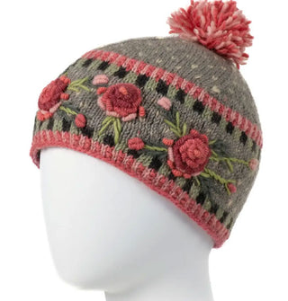 Gray-green wool beanie with textural pink, purple, and green floral embroidery, geometric border designs, and a two-tone pink pom pom on top
