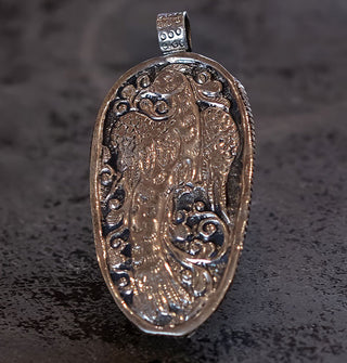 Silver pendant back side features engraved phoenix