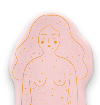 Closeup of the face and chest details on a flecked pink incense holder with gold illustrated outlines