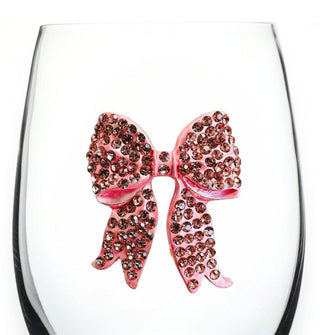 Closeup of a pink bow covered in pink rhinestone accents on the bowl of a clear wine glass