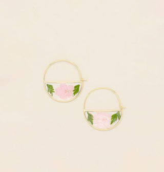 Gold hoop earrings with bottom semicircles containing resin-encased pressed pink flowers and green leaves