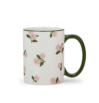 White porcelain mug features an all-over print of pink hydrangeas with green leaves and stems, and a dark green handle and rim