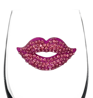 A clear stemless wine glass features a pink lips decal fully bejeweled in pink rhinestones
