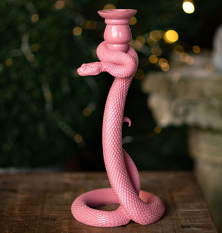 Pink taper candle holder with a body shaped like a scaly, slithering snake