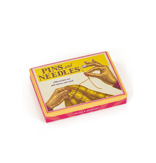 Flat rectangular box featuring a pair of hands sewing says, "Pins and Needles: I like when my shit turns out cool"