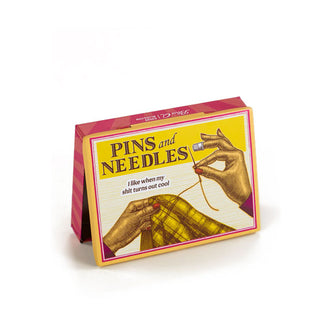 Flat rectangular box featuring a pair of hands sewing says, "Pins and Needles: I like when my shit turns out cool"