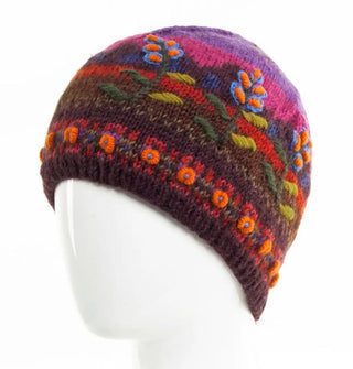 Colorful wool beanie features a mountain scene over-stitched with raised floral embroidery