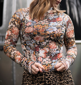 Model wears a long-sleeved floral print top with lettuce edges