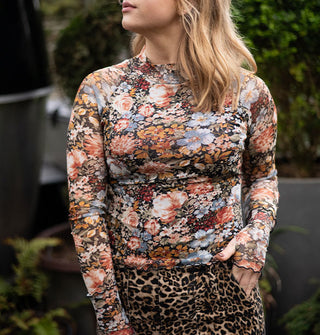 Model wears a long-sleeved floral print top with lettuce edges and thumholes