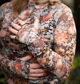 Model wears a long-sleeved floral print top with lettuce edges and thumbholes