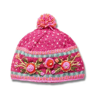 Bright pink wool beanie with textural pink, red, and green floral embroidery, geometric border designs, and a two-tone pink pom pom on top