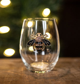 Clear stemless wine glass features a bumblebee decal bejeweled with rhinestones
