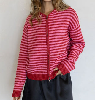 Model wears a red and pink striped zip-front hooded sweatshirt