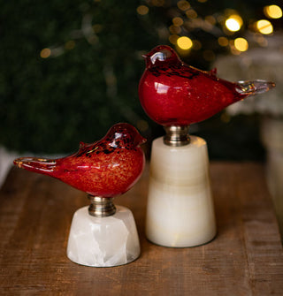 Set of two flecked red glass bird figurines affixed to marble bases with metal hardware