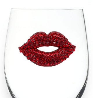 Red jewel-encrusted lips on the side of a clear wine glass