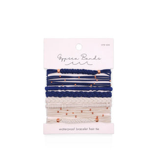 Set of woven Gypsea Bands Waterproof Bracelet Hair Ties in white and dark blue tones, some of which feature copper-colored beads