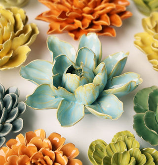 Blue ceramic nymphaea water lily wall art sculpture with yellow-gold edges surrounded by other colors and styles