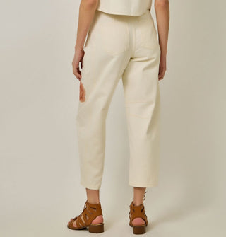 Model facing away from the camera wears a pair of white jeans with partial rose design visible on the left leg