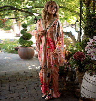 Model wears a maxi-length pink kimono-style robe with large floral print and contrast stripes along the hems