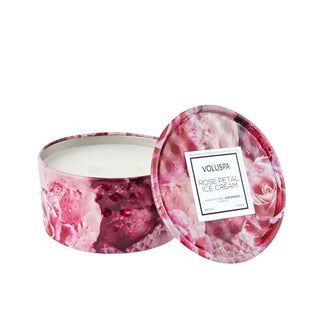 Decorative pink rose-patterned metal Rose Petal Ice Cream scented Voluspa candle tin with lid removed and propped up alongside