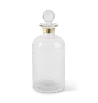 Rounded faceted glass decanter with gold band around the neck and a rounded stopper