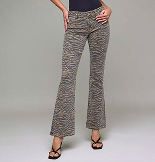Model with hands on hips wears a pair of flared tiger stripe jeans paired with strappy black heels