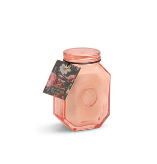 Octagonal peach-pink glass Saffron Rose scent candle jar with tag hanging from its neck