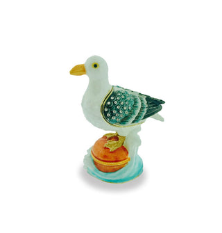 Decorative painted box is designed to resemble a seagull perched on the top of a pier piling surrounded by a crashing wave and is accented with small clear crystals on its wing and a gold-trimmed opening which forms the outline of the wing
