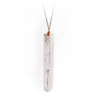 An elongated piece of selenite stone hangs from a gold chain