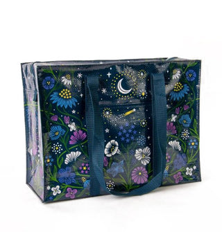 Rectangular black tote bag with dark blue woven handles features all-over floral and celestial print in blues, purples, and white with yellow accents