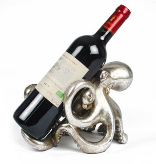 A bottle of wine is placed in the tentacles of a silver-toned octopus-shaped sculpture