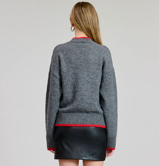 Model facing away from the camera wears a heather gray sweater with red-rimmed collar, cuffs, and bottom hem