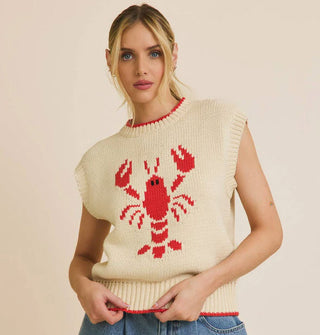Model wears a sleeveless cream-colored sweater with central red lobster design and red-rimmed neckline and bottom hem