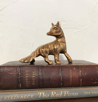 Brass fox figurine on top of a small stack of vintage books